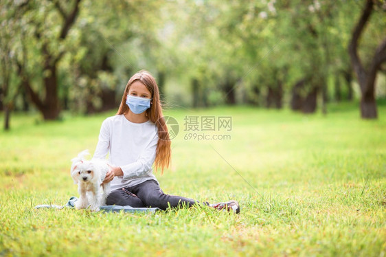 公园里抱着宠物狗的小女孩图片