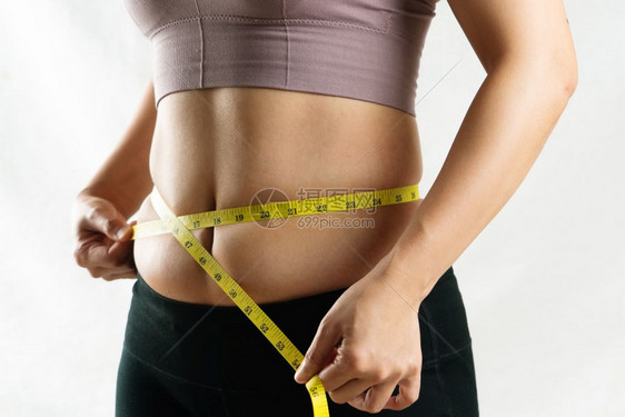 压力女士青年用计量胶带妇女饮食生活方式概念用衡量她过腹部脂肪腰的测量仪表带和妇女饮食生活方式概念损失图片