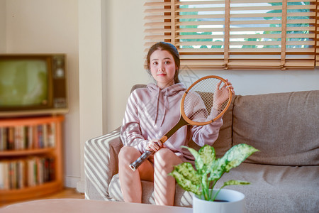 健康随意的快乐亚裔美貌可爱女子坐在房间里玩网球游戏快乐笑容图片