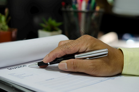 保持利润商人手笔记在帐单文件商业金融与营销上专业的图片