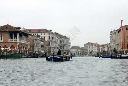 住宅威尼斯人一艘在意大利威尼斯运河上行驶的驳船男人图片