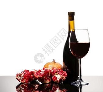 葡萄园工作室一种白色背景上的孤立葡萄酒瓶杯和多汁的石榴图片