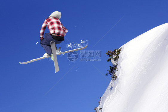 在雪上飞跃的滑雪者图片