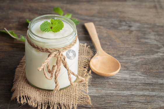 小吃产品乳制以玻璃瓶装酸奶和旧木桌板上纸薄粉为主的健康食品概念图片