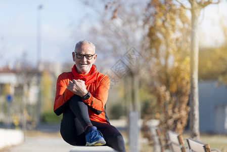 快乐的高级选手在公园慢跑后坐着赛者图片