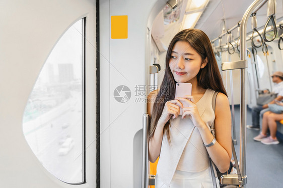 乘坐地铁看手机的年轻女孩图片