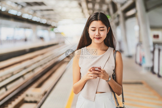 乘坐地铁看手机的年轻女孩图片