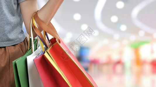 灯光顾客方便部分女手持购物纸袋而百货商店城市生活方式和商业概念中购物场面积背景模糊妇女手持这些纸袋图片