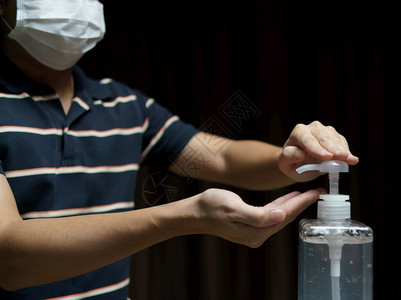 男人在检疫冠状概念中戴防护面罩用清洁剂液体抗菌凝胶清洗手部疾病工人打扫图片