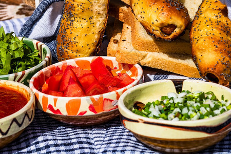 传统的有机由香肠卷和不同碗酱汁切开的蔬菜西红柿绿生洋葱大蒜组成的精细分厨房图片