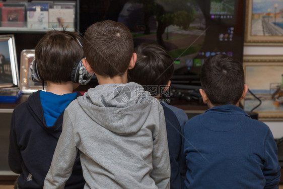 游戏玩家操纵杆控制器十岁儿童从后面看坐在电视机前玩子游戏十岁儿童从后面看图片