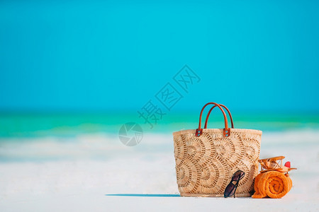 海滩上的草袋橙色毛巾和墨镜图片
