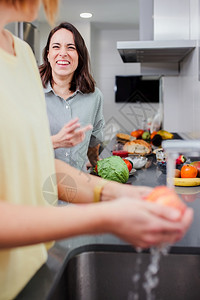 妇女准备健康食品在厨房里清洗一些蔬菜享受娱乐和饮食概念的营养妇女在厨房里做健康食物和洗菜盘子新鲜的屋图片