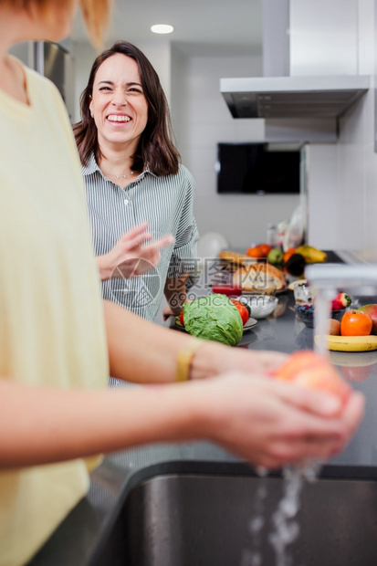 妇女准备健康食品在厨房里清洗一些蔬菜享受娱乐和饮食概念的营养妇女在厨房里做健康食物和洗菜盘子新鲜的屋图片