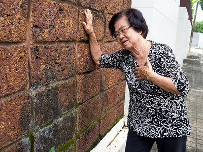 高级的患有胸部疼痛和的年长妇女由于心肌梗塞而抱住乳房心脏病发作概念关心女士图片