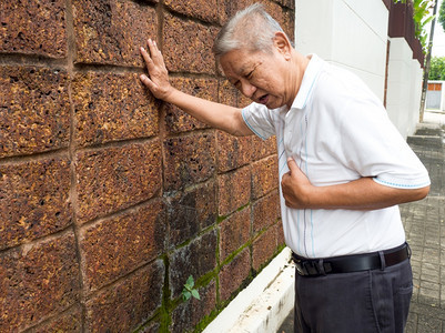 高年男子胸前疼痛且因心肌梗塞而抱住乳房的心脏病发作概念药物关心患病的背景图片