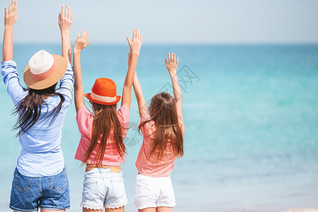 少女和年轻母亲在热带白沙滩上享受假期图片
