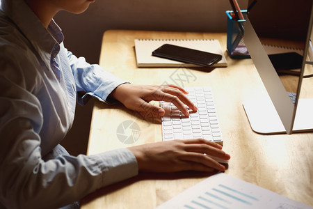 行政白色的笔记本电脑利用膝上型核对办公室财务数据的办公桌上女商业人图片