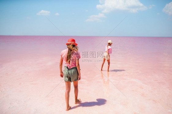 娱乐远征反射阳光明媚的夏日粉红盐湖上的快乐女孩阳光明媚的夏日粉红盐湖上的女孩们图片