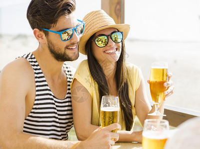 情侣在沙滩酒吧喝冷啤酒图片