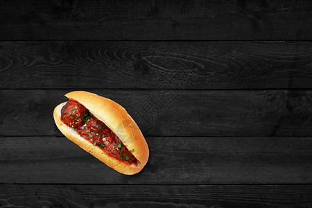肉饼木制的包子黑桌上孤立的西红柿热狗近视图片