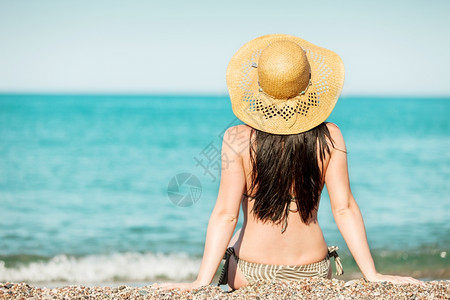 岛女坐在海边看水的相片她坐在海边采取夏威夷人图片