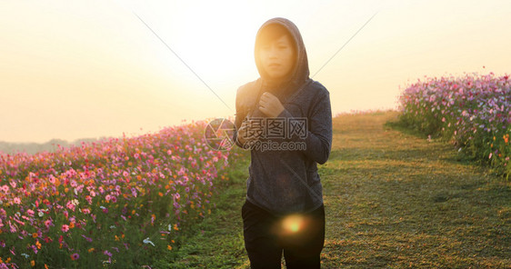 赛跑者年轻的成人亚裔妇女早上在宇宙花场慢跑图片