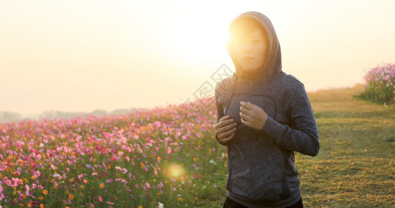 快乐的踪迹亚裔妇女早上在宇宙花场慢跑美丽的图片