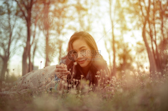 年轻的亚洲女人在秋天公园的摄像头面前摆姿势人们女孩浪漫的图片