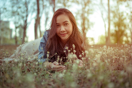 年轻的亚洲女人在秋天公园的摄像头面前摆姿势成人女外部图片
