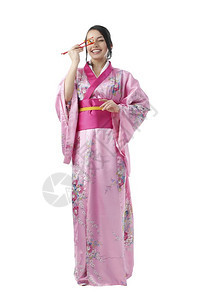 裙子美丽的日本年轻女子吃着两对筷的寿司穿着白色背景的传统喜莫诺服饰的全长肖像美貌的日本女青年用两对竹棍头吃寿司人类肩膀图片