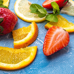 桌子甜的各种水果和草莓橙子柠檬和薄荷叶的种类平板地顶层风景蓝底草莓橘子柠檬和薄片叶顶层地板风景生姜图片