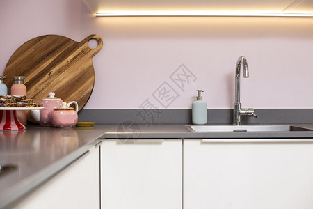 家关闭一个柜台和现代厨房钢槽配有粉色墙壁和装饰现代轻型室内清洁设备关闭一个柜台和现代厨房钢槽装饰粉红色墙和装饰现代光内建筑学胡椒图片