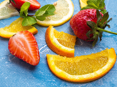 各种水果和草莓橙子柠檬和薄荷叶的种类平板地顶层风景蓝底草莓橘子柠檬和薄片叶顶层地板风景蓝色的甜生姜图片