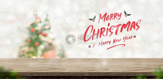 圣诞快乐和新年文字在木板上方的材桌顶模糊bokehxmas树装饰庆祝为了手写图片