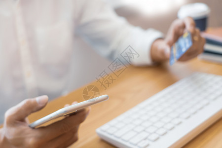技术手持临时衬衫的男子用信卡支付工资使用智能电话利移动银行应程序在线付款通过互联网在上购物下订单Onlinepay商人电子的图片