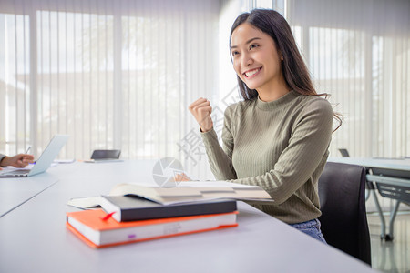 积极的女学生看着书给自己加油打气图片