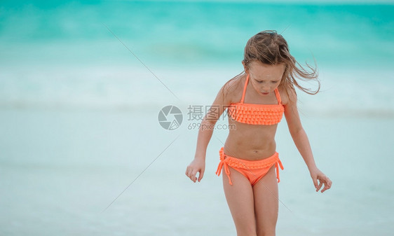 暑假小女孩在沙滩上玩耍图片