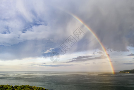 人们大彩虹在海雨后闪耀季节风景优美图片