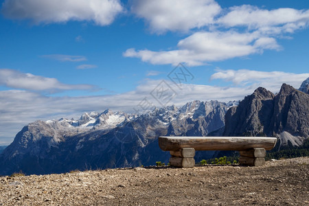旅行徒步团体在意大利多洛米提阿尔卑斯山峰贝卢诺省背景的木制长凳图片