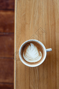 有选择焦点杯热拿铁艺术咖啡重点是白泡沫热拿铁艺术咖啡木制的食物文化图片