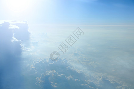阳光照耀的不平常云彩白色照亮了蓝天空背景闪亮的太阳和天堂全景窗般的美早晨太阳照耀着云层从飞机窗面拍出美妙的景色发光天际线蓝色图片