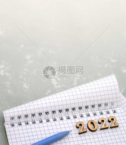 蓝色的床单灰笔记本和木制数字日期20一张空白纸和支蓝色笔桌上的记本和木数字日期一张空白纸和支圆珠笔种图片