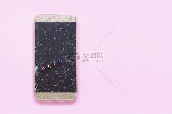 新的损坏电话破碎手机和粉红色背景上的文字oops概念复制空间平躺破碎的手机和粉红色背景上的文字图片
