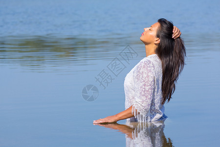 夏天黑色的舍内维尔身着长黑头发和白衣服的哥伦比亚妇女站在天然湖中图片