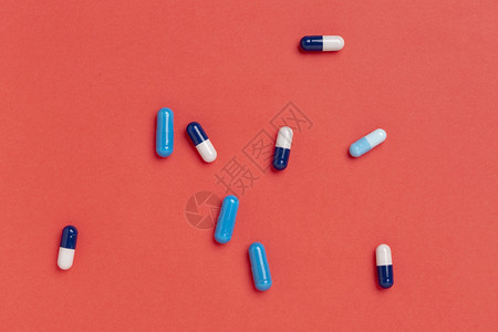 蓝药胶囊红色背景的蓝药物胶囊彩品单一颜色背景制药紧急情况反抗图片