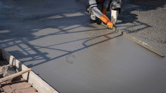 使用建筑工地板上石膏水泥的长三角形土绘制亚洲建筑工人的作物图象在建筑工具体的地面保护图片