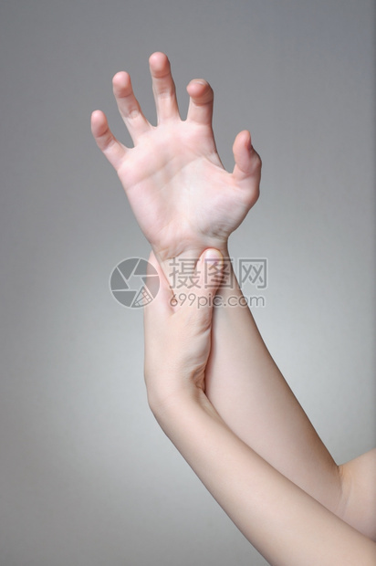 一位年轻女按摩她痛苦的手腕接触拉紧疼痛图片