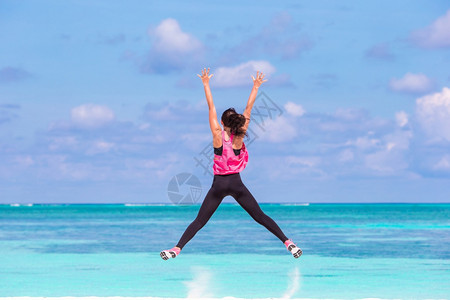 粉色蝴蝶结在海边做运动的女子背景