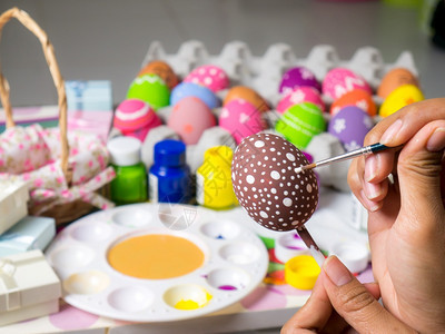 棕色的复活节妇女画在东方鸡蛋上的彩画在东方节的鸡蛋上美艺术作品以优美的方式与刷子一起绘制各种颜色的彩蛋染新图片
